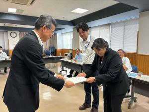 降旗委員長から住民自治局長へレポートが手渡されました。