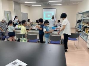 ペットボトルから繊維を作る装置を交錯する参加者