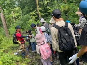 講師の話を聞きながら森を散策する参加者