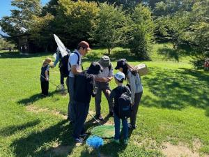 捕まえたトンボを観察する参加者