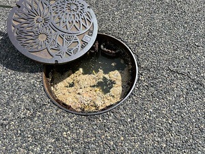 油で水のあふれそうなマンホール